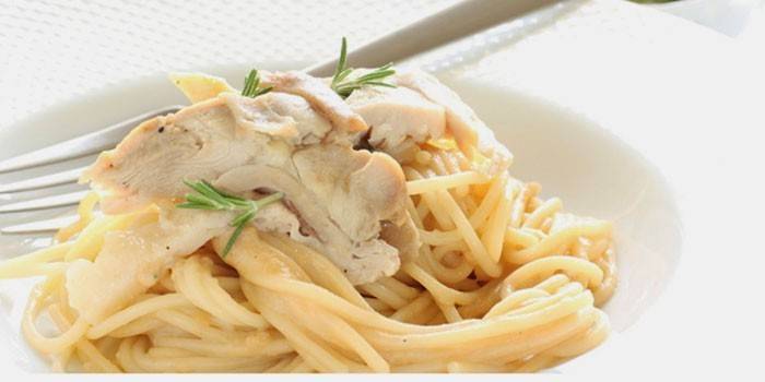 Паста с куриным мясом в сливочном соусе на тарелке